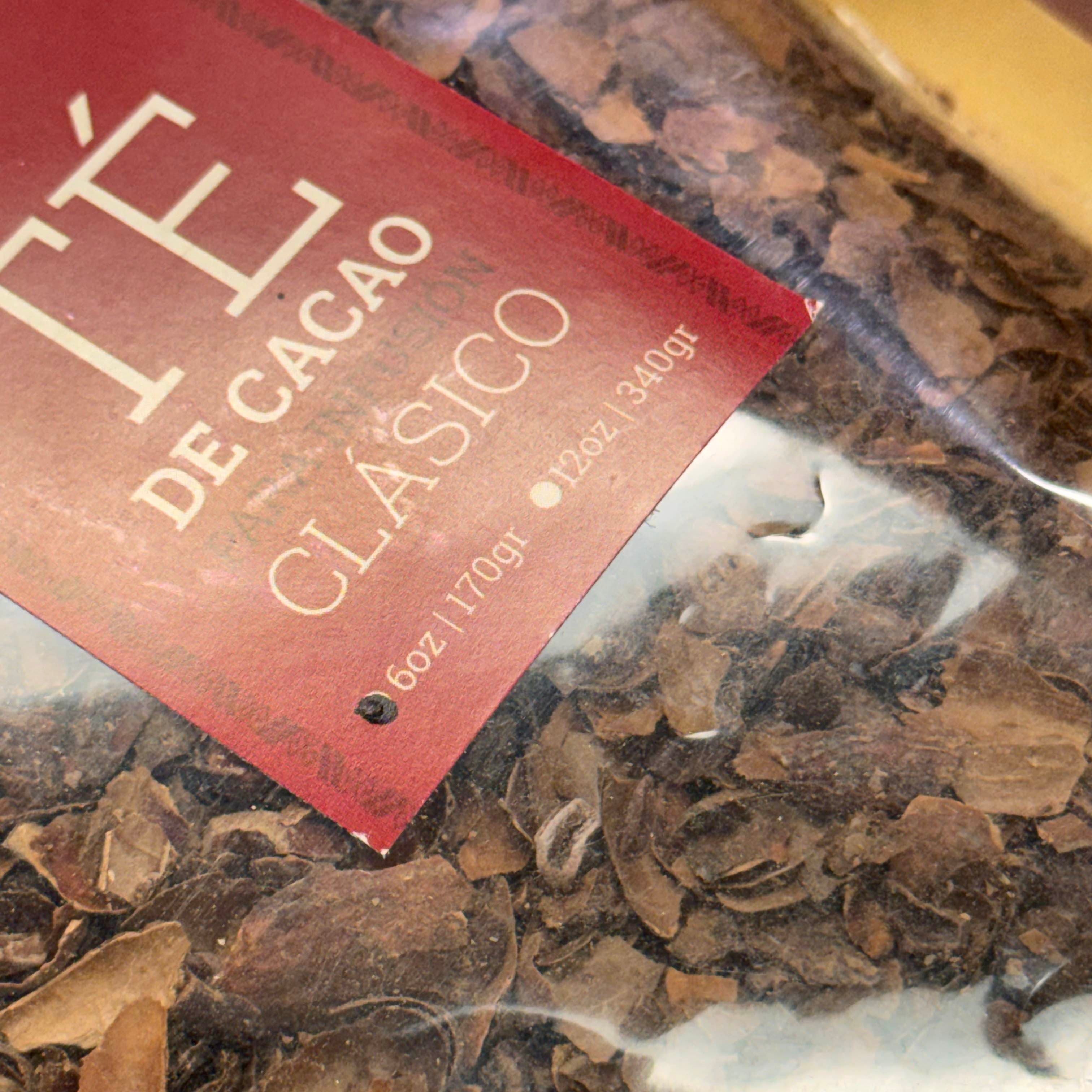 Cacao beans in a bag with a red label on a dark surface