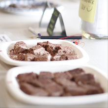Load image into Gallery viewer, Close-up of a chocolate dessert in a white container with a blurred background